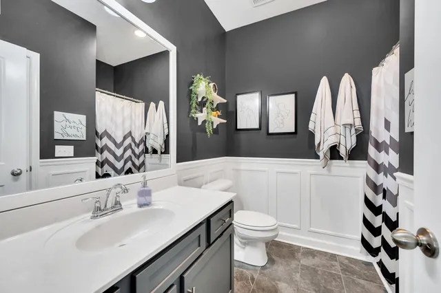 a bathroom with a toilet sink and mirror