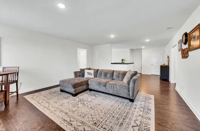 a living room with furniture and wooden floor