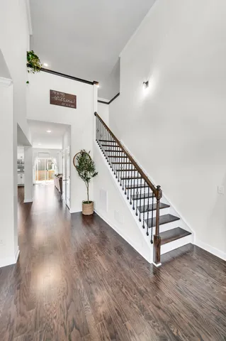 a view of a hallway with wooden floor and stairs