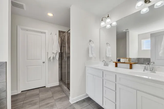 a bathroom with double vanity sinks a vanity a lamp and a mirror
