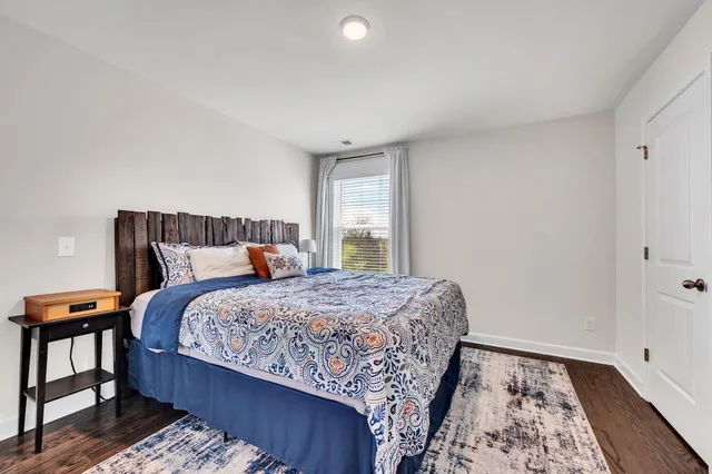 a bedroom with bed and wooden floor
