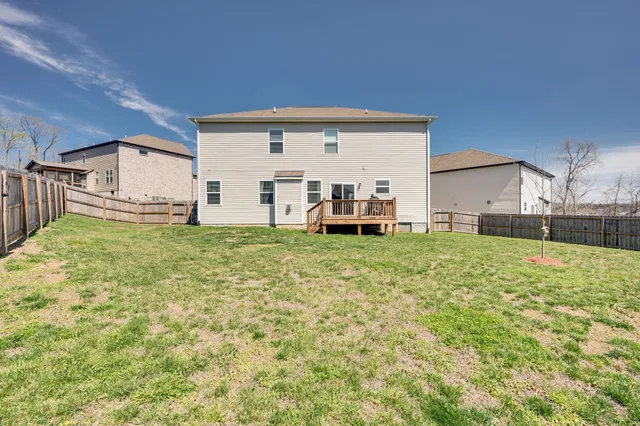 a view of a house with a big yard and large trees