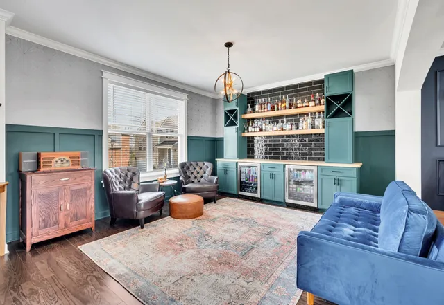 a living room with furniture a rug kitchen view and a chandelier