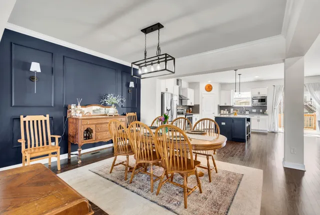 a dining room filled chandelier and wooden floor