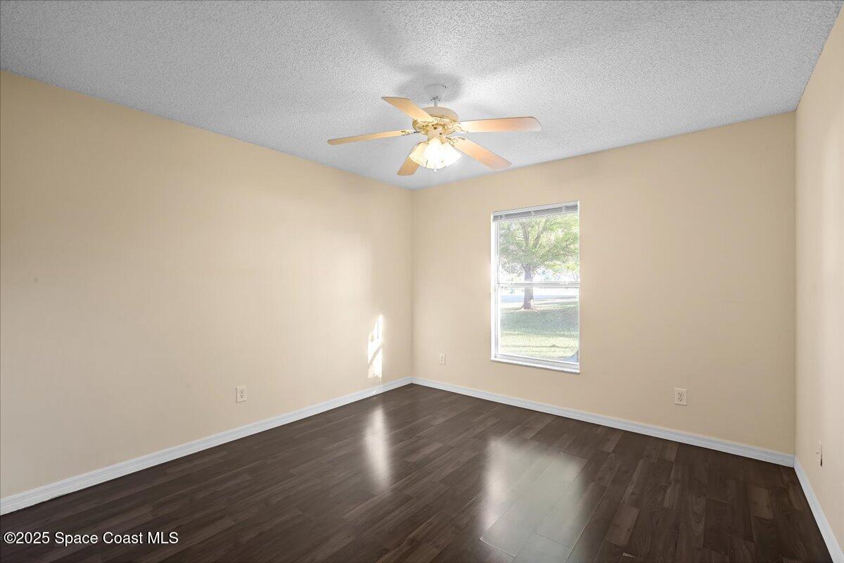295 Oak Lake Road Melbourne, FL 32901 - Photo 23 of 40 a view of an empty room with wooden floor and a window