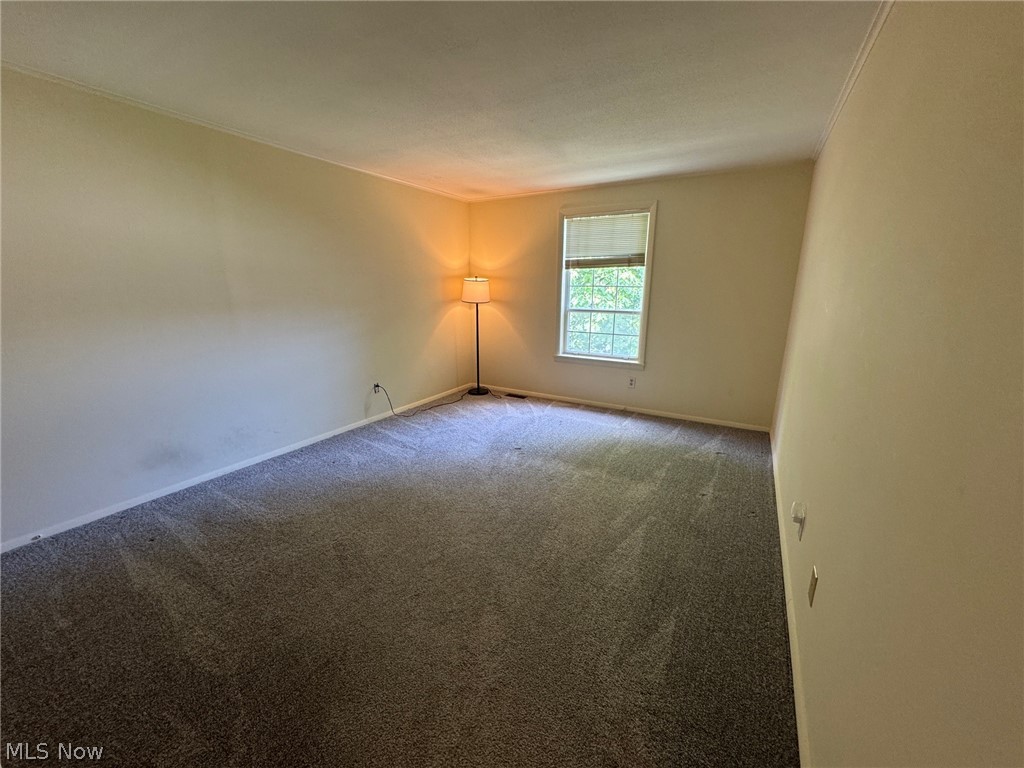 7294 Fox Mill Road, Unit 19D Mentor, OH 44060 - Photo 17 of 27 Carpeted room featuring light-colored walls and a single window with blinds