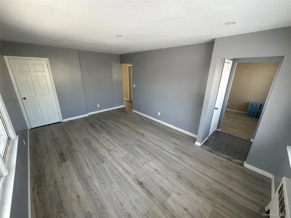 an empty room with wooden floor and mirror