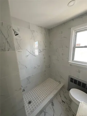 a bathroom with a sink toilet and window