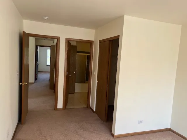 a view of a hallway with closet and wooden floor