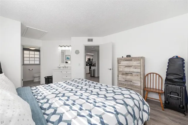 a bedroom with a large bed and wooden floor