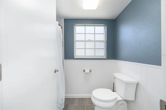 a white toilet sitting next to a window