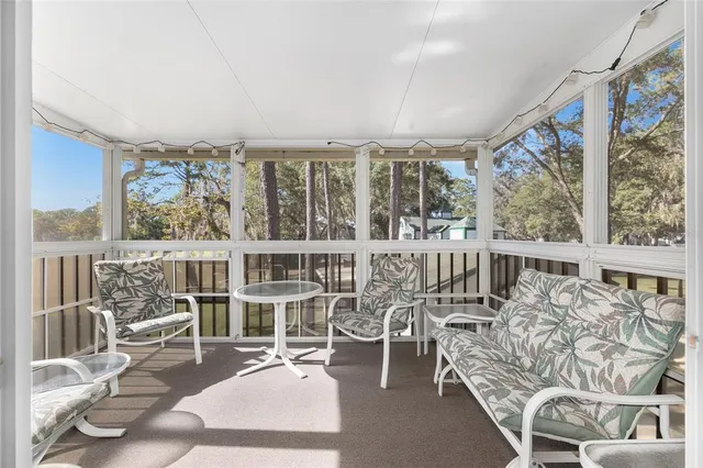 a view of a living room with furniture and floor to ceiling windows