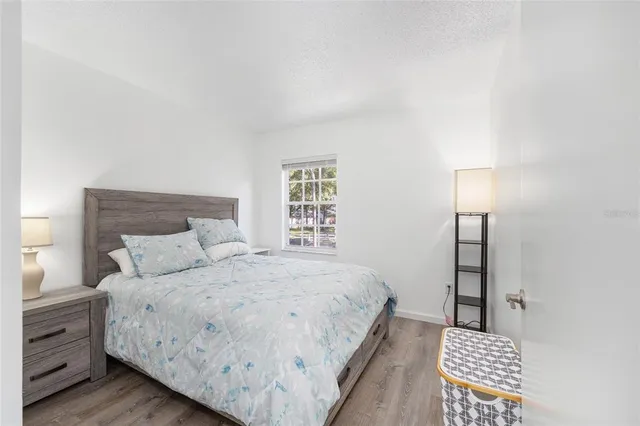 a bedroom with a bed and a lamp on dresser