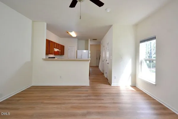 a view of a livingroom with wooden floor and a ceiling fan