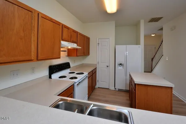 a kitchen with stainless steel appliances granite countertop a sink stove and refrigerator
