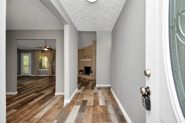 a view of a hallway with wooden floor and staircase