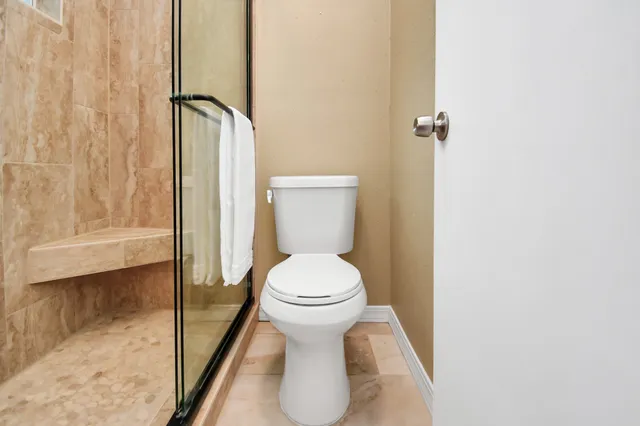 a bathroom with a toilet and a shower