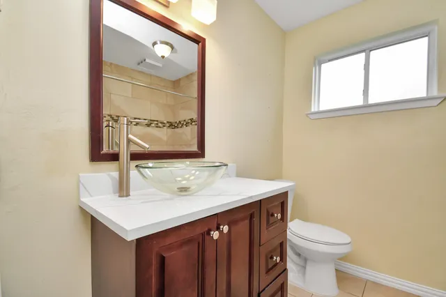 a bathroom with a sink a toilet and mirror