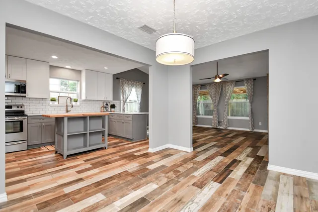 a large kitchen with a center island and stainless steel appliances