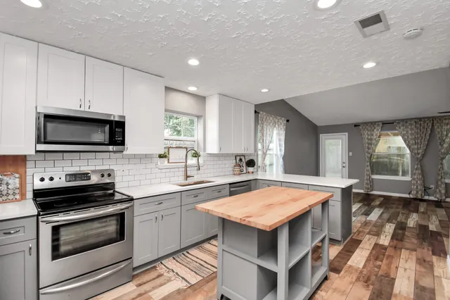 a kitchen with a stove a sink and a microwave