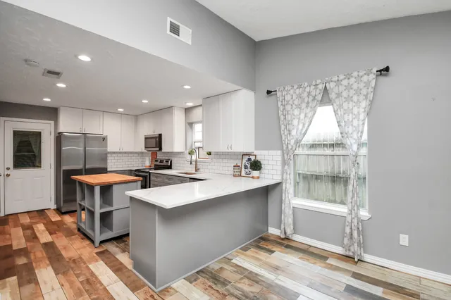 a large kitchen with a large counter top appliances and cabinets