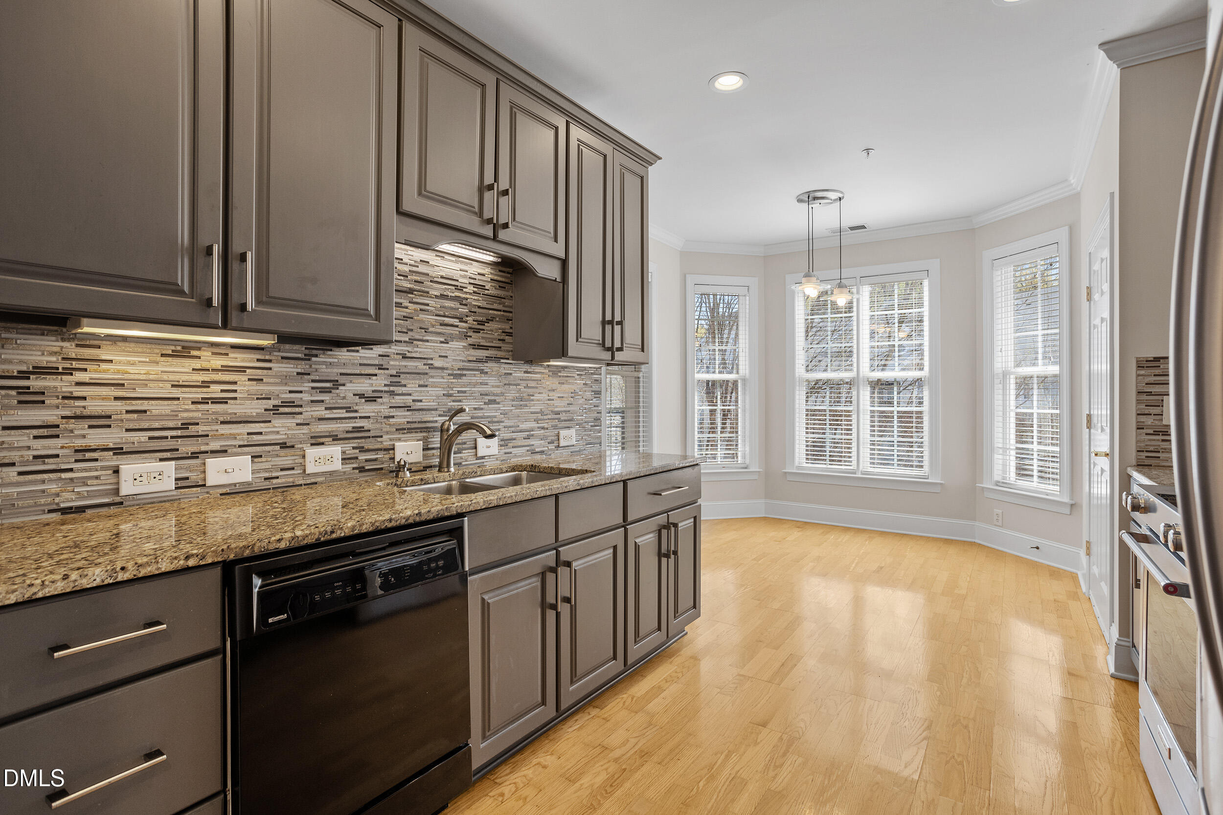 3700 Baron Cooper Pass, Unit 204 Raleigh, NC 27612 - Photo 19 of 45 a kitchen with granite countertop a sink stainless steel appliances wooden floor and a counter top space