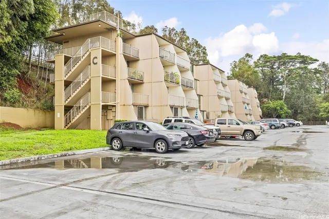 front view of a building with a garden and parking space