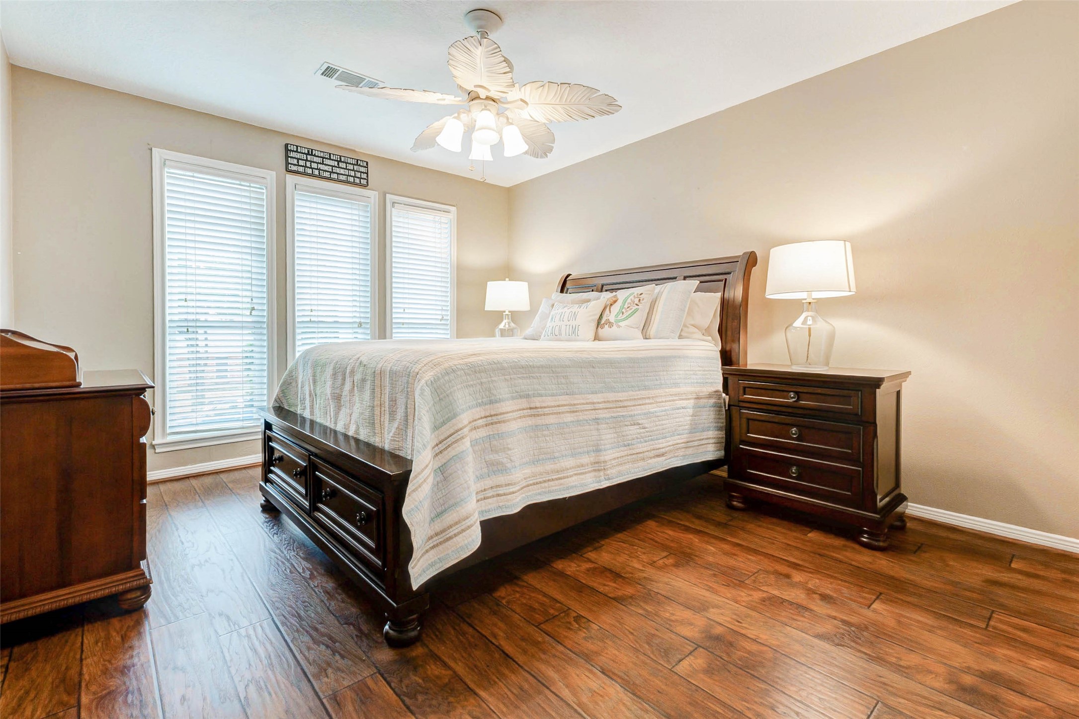 15811 Spring Forest Drive Houston, TX 77059 - Photo 15 of 27 This inviting secondary bedroom boasts warm wood laminate flooring, ample natural light from large windows, and elegant furnishings, creating a cozy and serene retreat.
