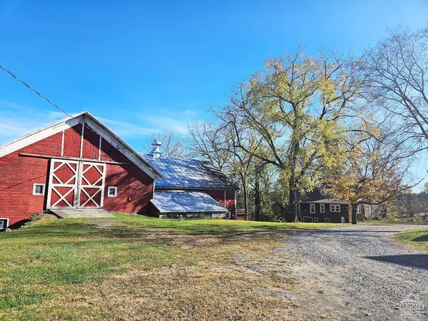 a view of a house with a yard and large tree