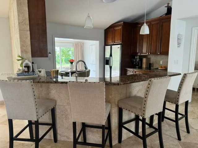 a kitchen with a table chairs sink and cabinets