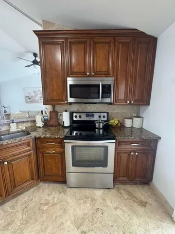 a kitchen with granite countertop stainless steel appliances and wooden cabinets