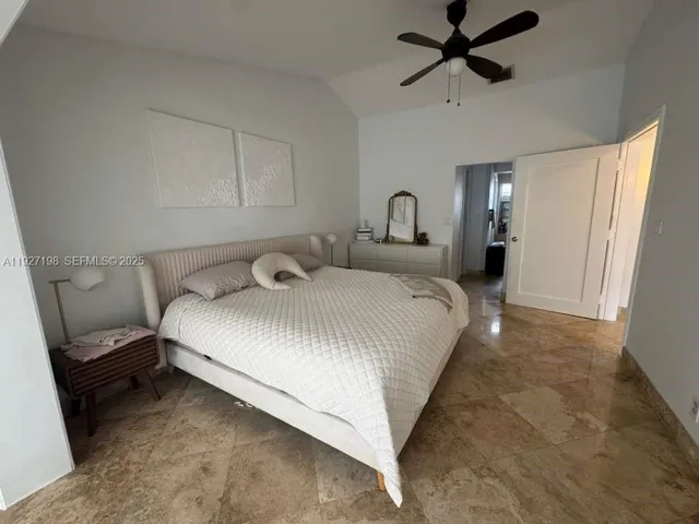 a bedroom with a bed and a ceiling fan
