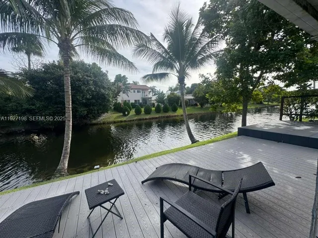 a view of a backyard with sitting area and lake view