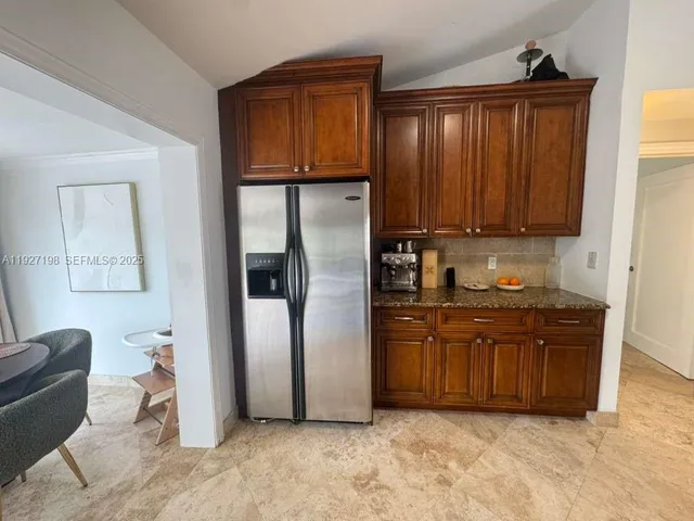 a kitchen with stainless steel appliances granite countertop a refrigerator and a sink