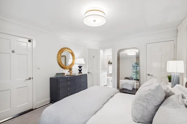 a cabinet with painting on the wall and a potted plant