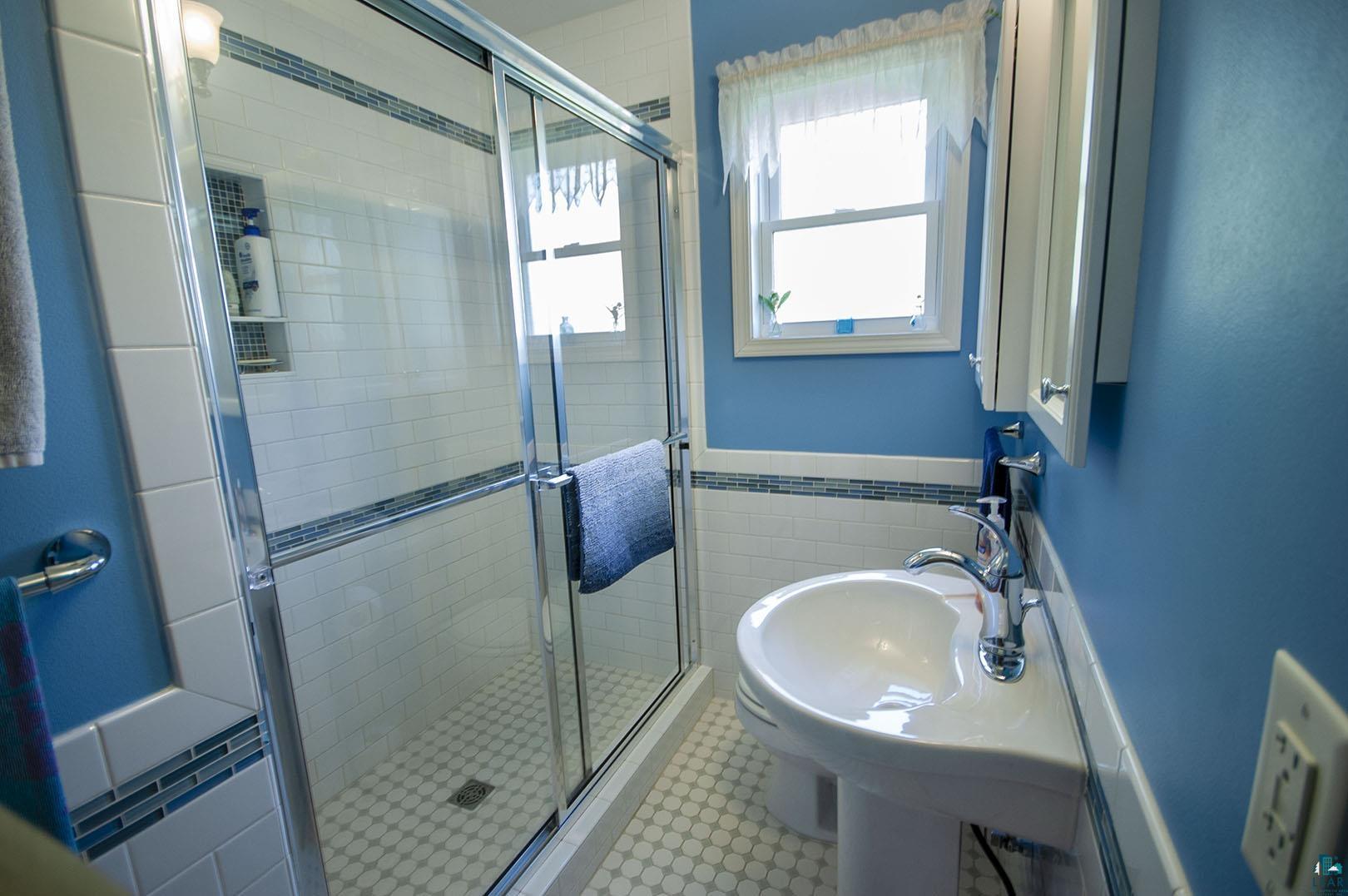 4726 Hermantown Road Hermantown, MN 55811 - Photo 28 of 40 Bathroom with an enclosed shower, tile patterned flooring, and tile walls