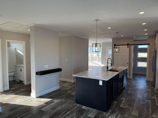 a kitchen with a sink a counter top space and stainless steel appliances