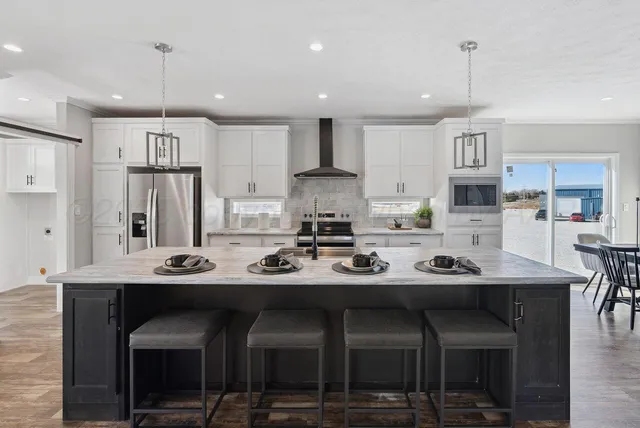 a kitchen with kitchen island granite countertop a refrigerator and a sink