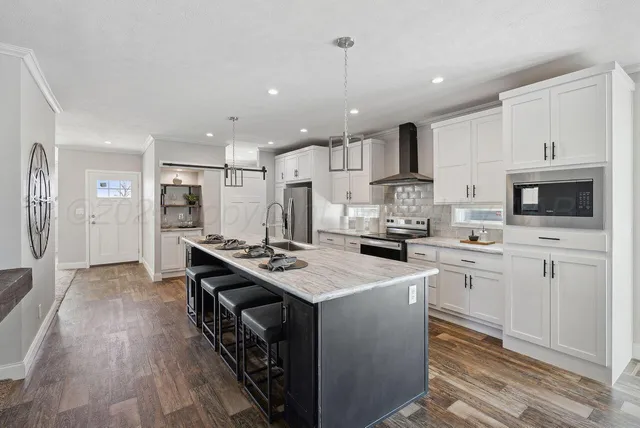 a kitchen with stainless steel appliances granite countertop a stove refrigerator and cabinets