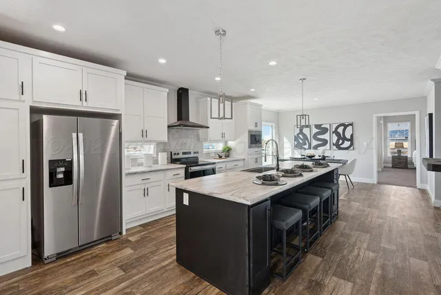 a view of kitchen with kitchen island sink and refrigerator