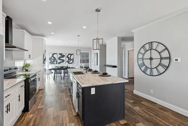 a kitchen with kitchen island a refrigerator sink and cabinets