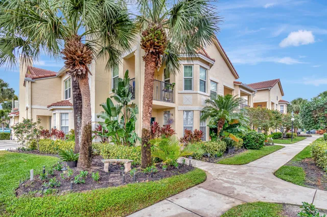 a front view of multi story residential apartment building with yard and green space