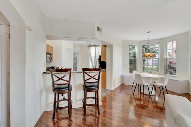 a kitchen with granite countertop white cabinets stainless steel appliances and a counter space