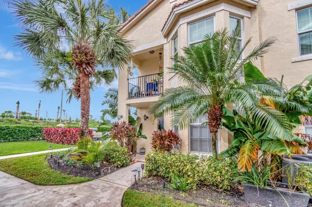 a front view of a house with a yard and potted plants