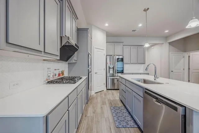 a kitchen with a sink stove and cabinets