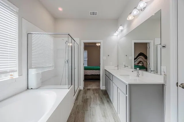 a bathroom with a double vanity sink a mirror and shower