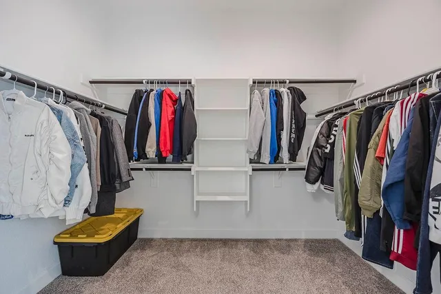 a view of walk in closet with clothes and shoes