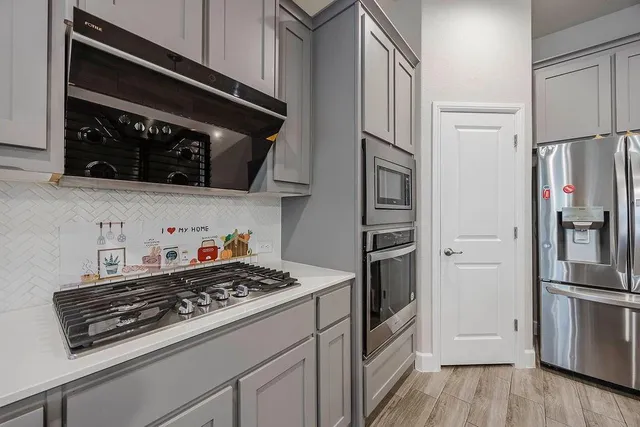 a kitchen with stainless steel appliances a stove a microwave and a refrigerator