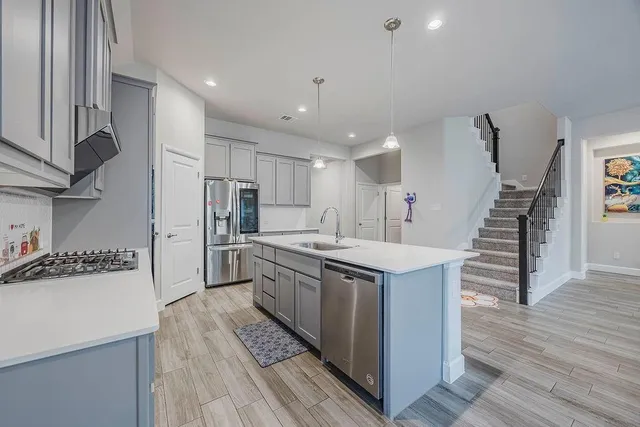 a kitchen with stainless steel appliances kitchen island granite countertop a stove and a refrigerator
