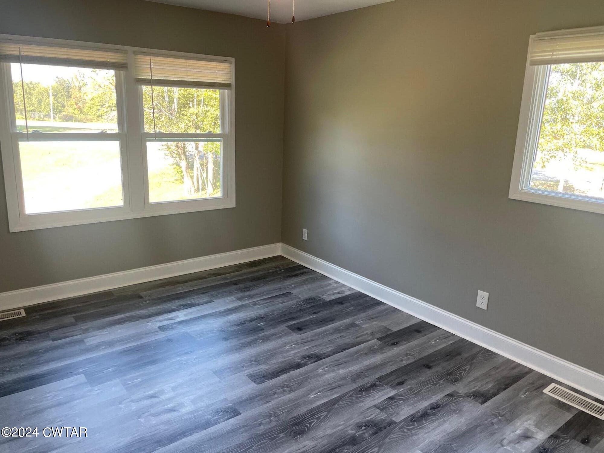 113 Ebenezer Road Mercer, TN 38392 - Photo 12 of 36 an empty room with wooden floor and a window